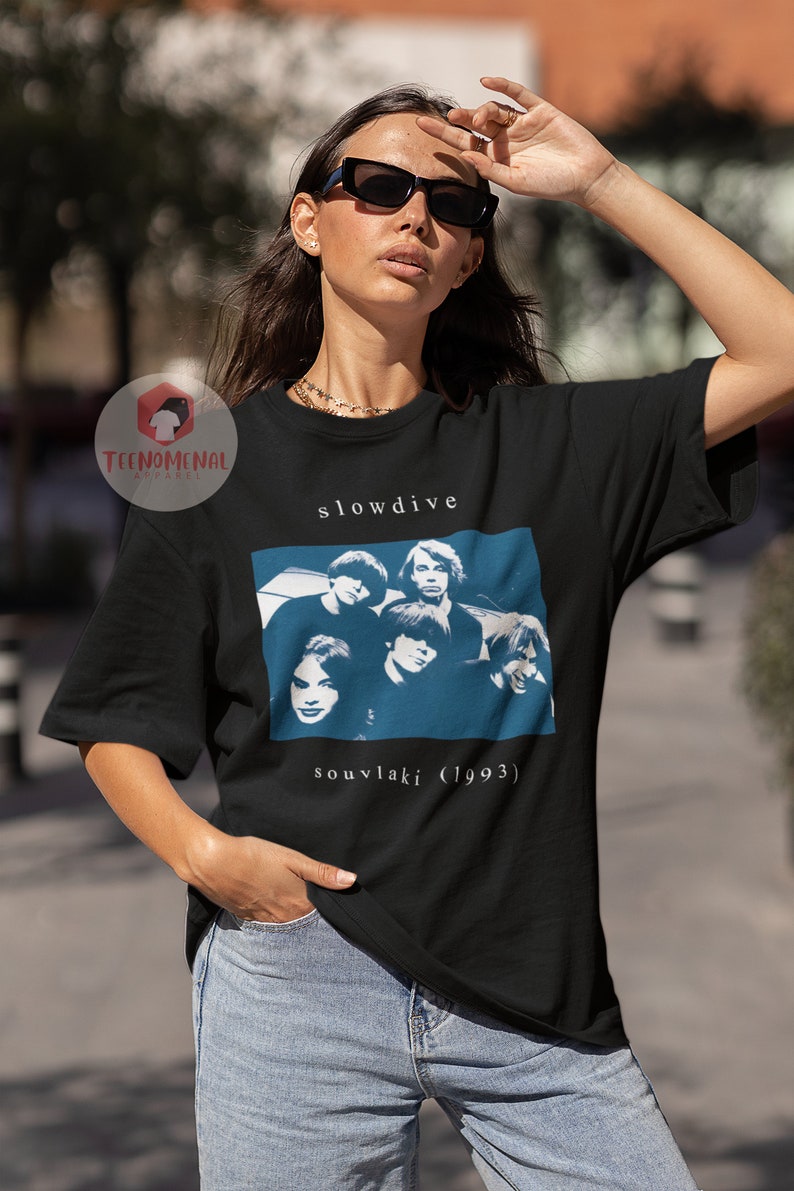 Puede incluir: Camiseta negra con un gr&aacute;fico blanco de la banda Slowdive. El gr&aacute;fico incluye una foto de los miembros de la banda y el texto "souvlaki (1993)".