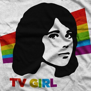 May include: A black and white illustration of a woman with long hair, with a rainbow flag behind her. The text "TV GIRL" is below the image.