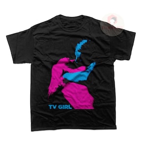 May include: Black t-shirt with a pink and blue silhouette of a person and the text "TV GIRL" in blue.