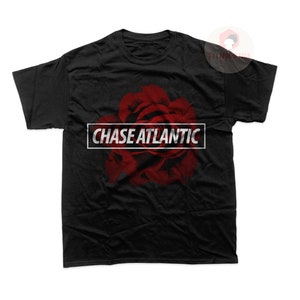 May include: Black t-shirt featuring a red rose graphic and the text "CHASE ATLANTIC" in a white rectangle.