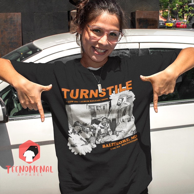 May include: Black t-shirt with a white and gray graphic of a band called Turnstile. The graphic includes the text "Glow On" and "Album Release Show". The text "Baltimore, MD" and "04/01/21 Soundstage" is also included in the graphic.