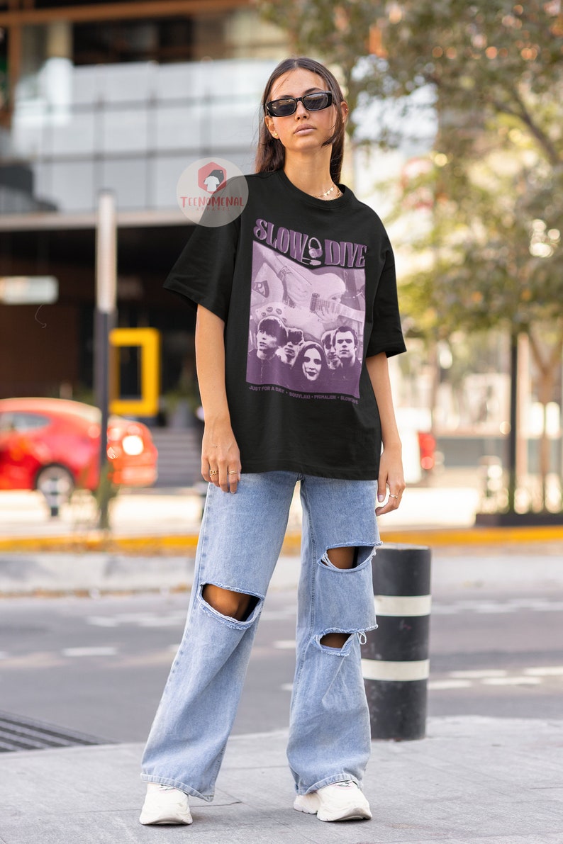 May include: A black t-shirt with a purple graphic print of a band called "Slowdive". The graphic features a band photo and the text "Just for a Day - Souvlaki - Pygmalion -  Slowdive".