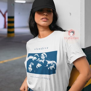 Puede incluir: Camiseta blanca con un gr&aacute;fico azul de la banda Slowdive y el t&iacute;tulo del &aacute;lbum "souvlaki (1993)".