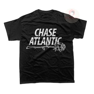 May include: Black t-shirt with a white graphic design that says "CHASE ATLANTIC" with a rose underneath the text.