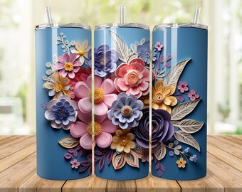 Può includere: Tre bicchieri blu in acciaio inossidabile con un design floreale. Il design presenta fiori di carta a strati nei toni del rosa, giallo, viola e arancione. Ogni bicchiere ha un coperchio argentato e una cannuccia trasparente.