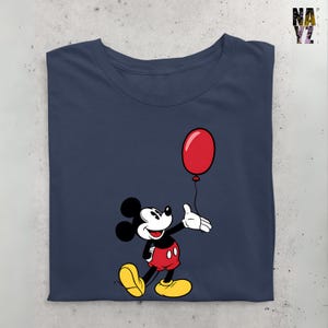 May include: A navy blue t-shirt with a cartoon image of Mickey Mouse holding a red balloon. Mickey Mouse is wearing red shorts and yellow shoes.