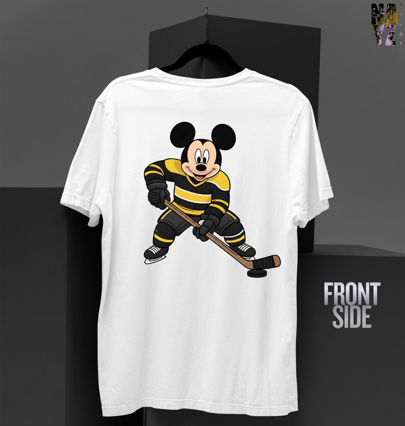 May include: White t-shirt featuring a cartoon Mickey Mouse character in a hockey uniform with black and yellow stripes, holding a hockey stick. The words "FRONT SIDE" are printed on the right side of the shirt.