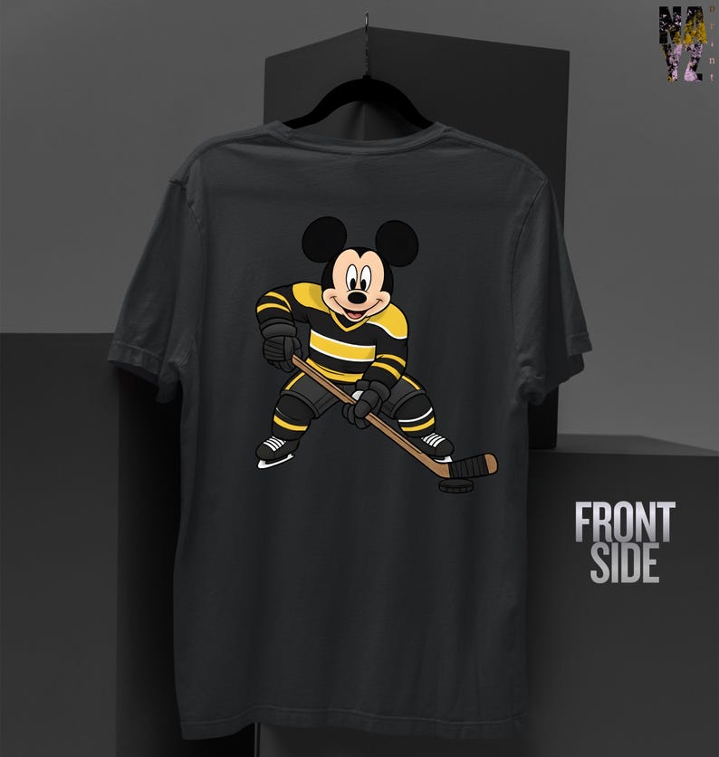 May include: Dark gray t-shirt featuring a cartoon Mickey Mouse character in a hockey uniform with black and yellow stripes, holding a hockey stick. The shirt has the words "FRONT SIDE" printed on the right side.