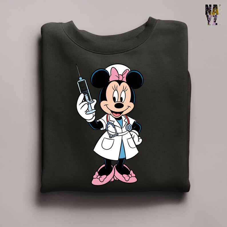 Peut inclure: Sweat-shirt noir avec un dessin anim&eacute; de Minnie Mouse habill&eacute;e en infirmi&egrave;re. Minnie Mouse porte une blouse blanche, des chaussures roses et un bonnet d'infirmi&egrave;re avec un n&oelig;ud rose. Elle tient une seringue. Le sweat-shirt est pli&eacute;.