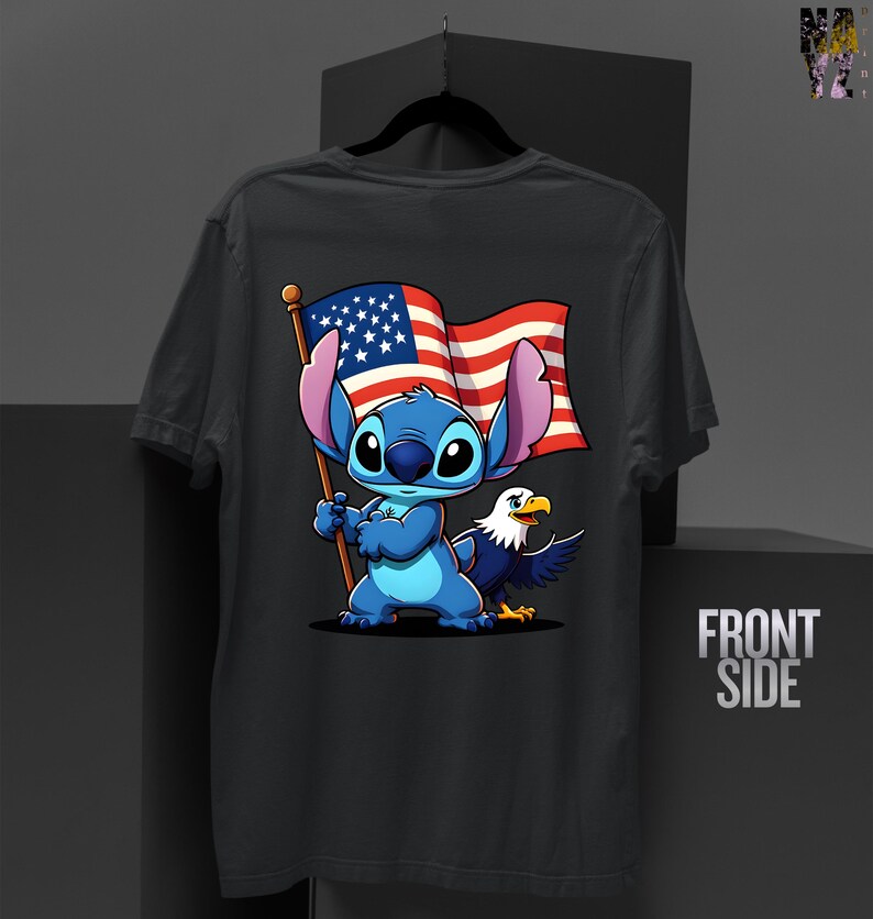 May include: Dark gray t-shirt featuring a cartoon Stitch character holding an American flag, with an eagle beside him. The flag has red and white stripes and blue stars. The words "FRONT SIDE" are printed on the right side.