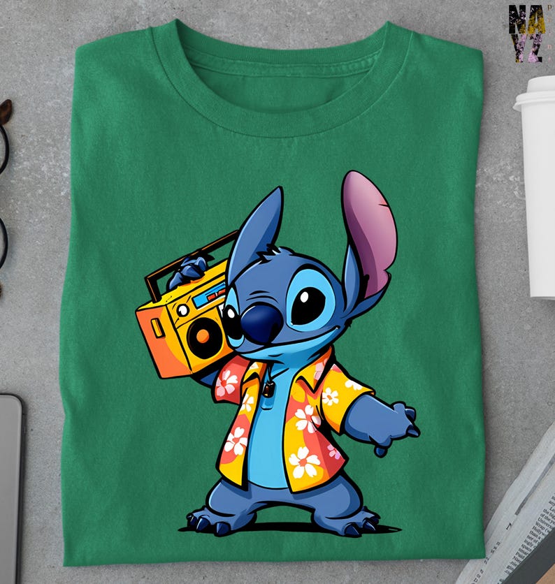 Op de afbeelding: Groen t-shirt met een cartoon illustratie van Stitch, die een gele boombox vasthoudt. Stitch draagt een Hawaiiaans shirt met een bloemenpatroon. Het ontwerp is gecentreerd op het shirt.