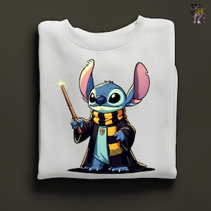 Pode incluir: Camisola branca com uma ilustra&ccedil;&atilde;o de desenho animado de Stitch de Lilo & Stitch vestido de mago. Stitch &eacute; azul com orelhas grandes, usando uma t&uacute;nica preta, um cachecol listrado e segurando uma varinha com a ponta brilhante. O design est&aacute; centrado na camisola dobrada.