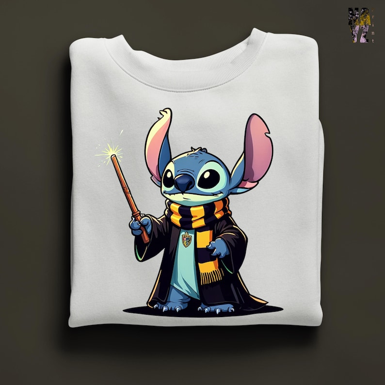 Pode incluir: Camisola branca com uma ilustra&ccedil;&atilde;o de desenho animado de Stitch de Lilo & Stitch vestido de mago. Stitch &eacute; azul com orelhas grandes, usando uma t&uacute;nica preta, um cachecol listrado e segurando uma varinha com a ponta brilhante. O design est&aacute; centrado na camisola dobrada.