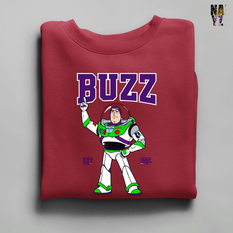 May include: Burgundy crewneck sweatshirt featuring a cartoon image of Buzz Lightyear with the word "BUZZ" above him in purple and white. The sweatshirt also has the text "EST 1995" below the character.