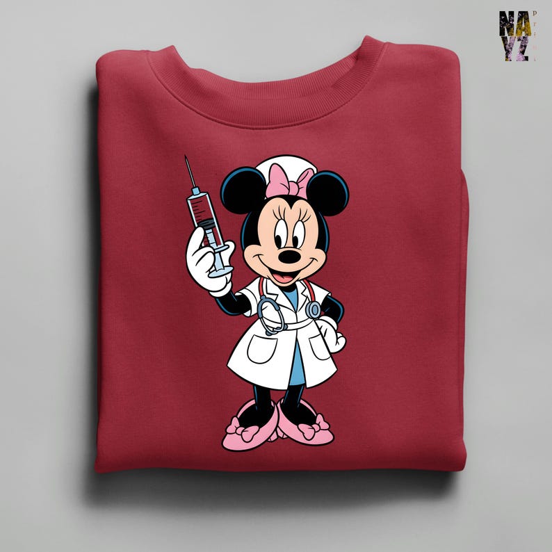 Peut inclure: Sweat-shirt bordeaux avec Minnie Mouse en infirmi&egrave;re, tenant une seringue. Minnie Mouse porte une blouse blanche, un n&oelig;ud rose et un st&eacute;thoscope. Le motif est centr&eacute; sur le devant du sweat-shirt.