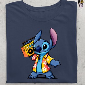 Op de afbeelding: Marineblauw T-shirt met een cartoonfiguur, Stitch, die een gele boombox vasthoudt. Stitch draagt een geel Hawaiiaans shirt met witte en oranje bloempatronen. Het shirt heeft een knoopkraag. De afbeelding is een grafisch ontwerp.