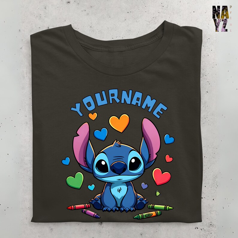 K&ouml;nnte beinhalten: Ein dunkelgraues T-Shirt mit einer blauen Stitch-Figur aus dem Disney-Film Lilo & Stitch. Stitch ist von bunten Herzen und Buntstiften umgeben. Der Text "YOURNAME" ist &uuml;ber Stitch gedruckt.