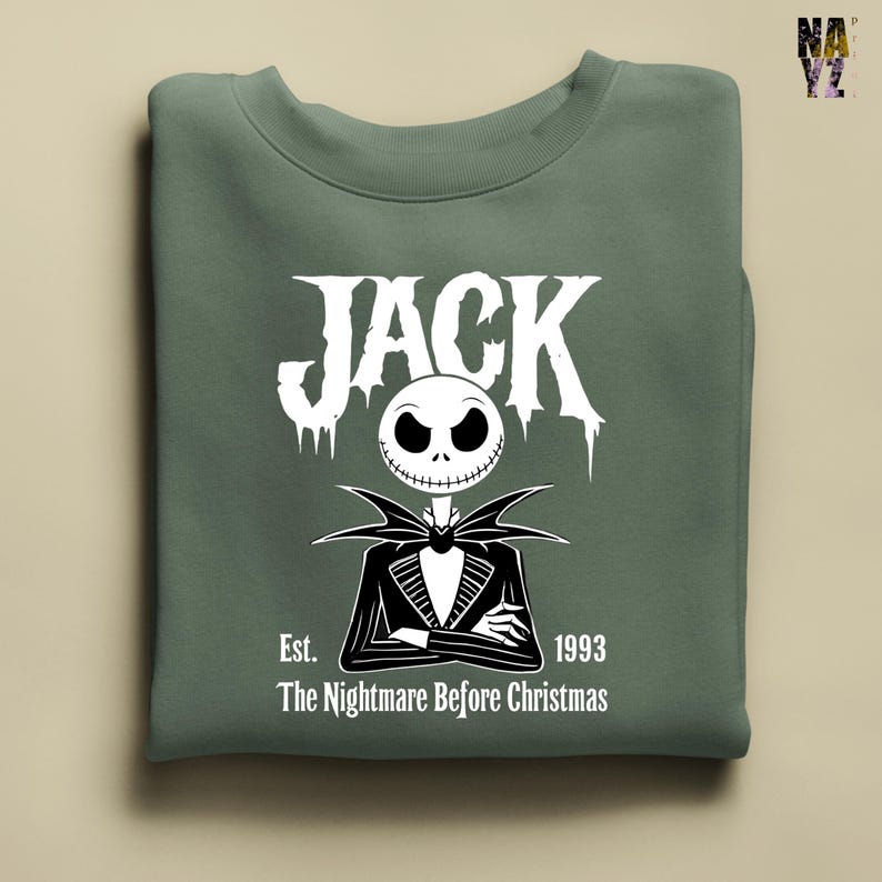 Puede incluir: Sudadera verde salvia con un gr&aacute;fico blanco de Jack Skellington de "Pesadilla antes de Navidad". El dise&ntilde;o incluye la palabra "JACK" en una fuente estilizada sobre una ilustraci&oacute;n de Jack, con el texto "Est. 1993" y "The Nightmare Before Christmas" debajo.