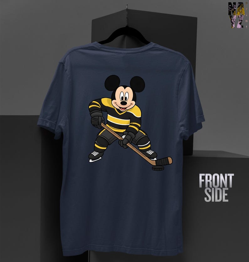 May include: Navy blue t-shirt featuring a cartoon Mickey Mouse in a hockey uniform with black and yellow stripes, holding a hockey stick. The shirt has the words "FRONT SIDE" printed on the right side.