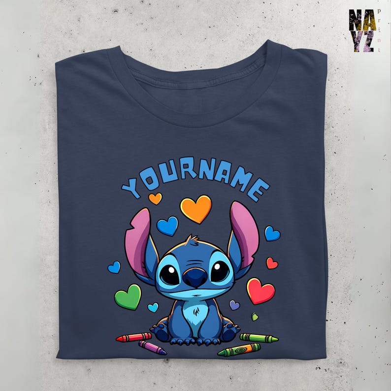 K&ouml;nnte beinhalten: Ein marineblaues T-Shirt mit einer Zeichentrickfigur Stitch, umgeben von bunten Herzen und Buntstiften. Der Text "YOUR NAME" ist &uuml;ber Stitch gedruckt.