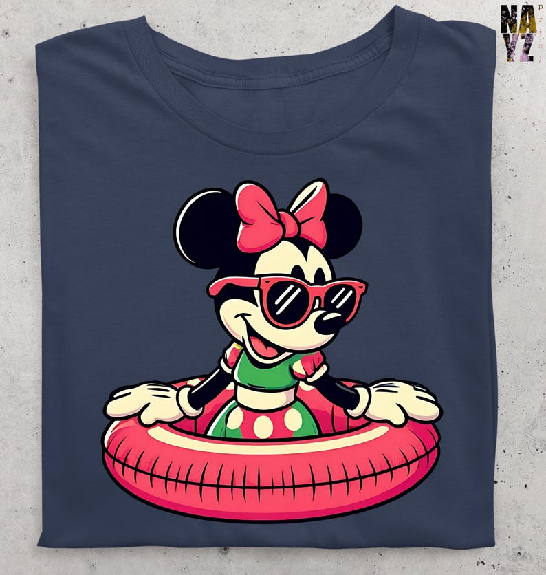May include: Navy blue t-shirt with a cartoon Minnie Mouse design. Minnie Mouse is wearing sunglasses and a pink bow, and is in a red and pink inflatable ring. She is wearing a green and red polka dot dress. The shirt is folded.