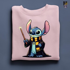 Pode incluir: Um moletom rosa claro com um personagem de desenho animado vestido com uma t&uacute;nica e cachecol de mago, segurando uma varinha. O personagem &eacute; azul com orelhas e olhos grandes. O cachecol &eacute; preto e amarelo. A varinha tem uma ponta brilhante.