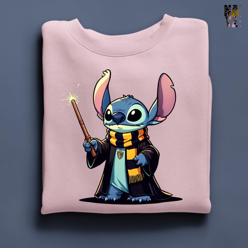 Pode incluir: Um moletom rosa claro com um personagem de desenho animado vestido com uma t&uacute;nica e cachecol de mago, segurando uma varinha. O personagem &eacute; azul com orelhas e olhos grandes. O cachecol &eacute; preto e amarelo. A varinha tem uma ponta brilhante.