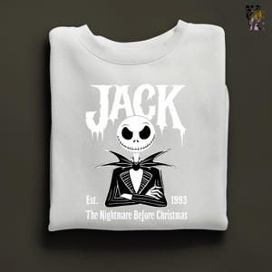 Puede incluir: Sudadera blanca con un gr&aacute;fico en blanco y negro de Jack Skellington de The Nightmare Before Christmas. El dise&ntilde;o incluye la palabra "JACK", una cara esquel&eacute;tica y el texto "Est. 1993 The Nightmare Before Christmas".