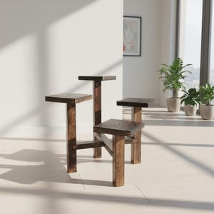 Puede incluir: Un conjunto de cuatro soportes para plantas de madera marr&oacute;n oscuro de diferentes alturas. Cada soporte tiene una parte superior cuadrada y una base rectangular resistente. Los soportes est&aacute;n dispuestos en una habitaci&oacute;n con luz natural.