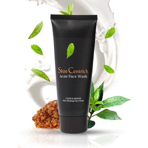 Könnte beinhalten: Eine schwarze Tube Skin Centrick Acne Face Wash mit grünen Blättern. Das Produkt ist mit "CLEAR & REPAIR Skin Healing Face Wash" beschriftet. Das Bild enthält einen Spritzer weißer Flüssigkeit und verstreute grüne Blätter.