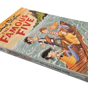 May include: A hardcover book titled "The Famous Five" by Enid Blyton. The cover features an illustration of five children in a boat on water. The book's title is in large red letters, with the author's name in a smaller font.