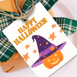 Puede incluir: Un regalo envuelto en papel marrón con cinta de cuadros verdes y una etiqueta que dice "HAPPY HALLOWEEN". La etiqueta presenta una calabaza de dibujos animados con un sombrero de bruja y estrellas naranjas.