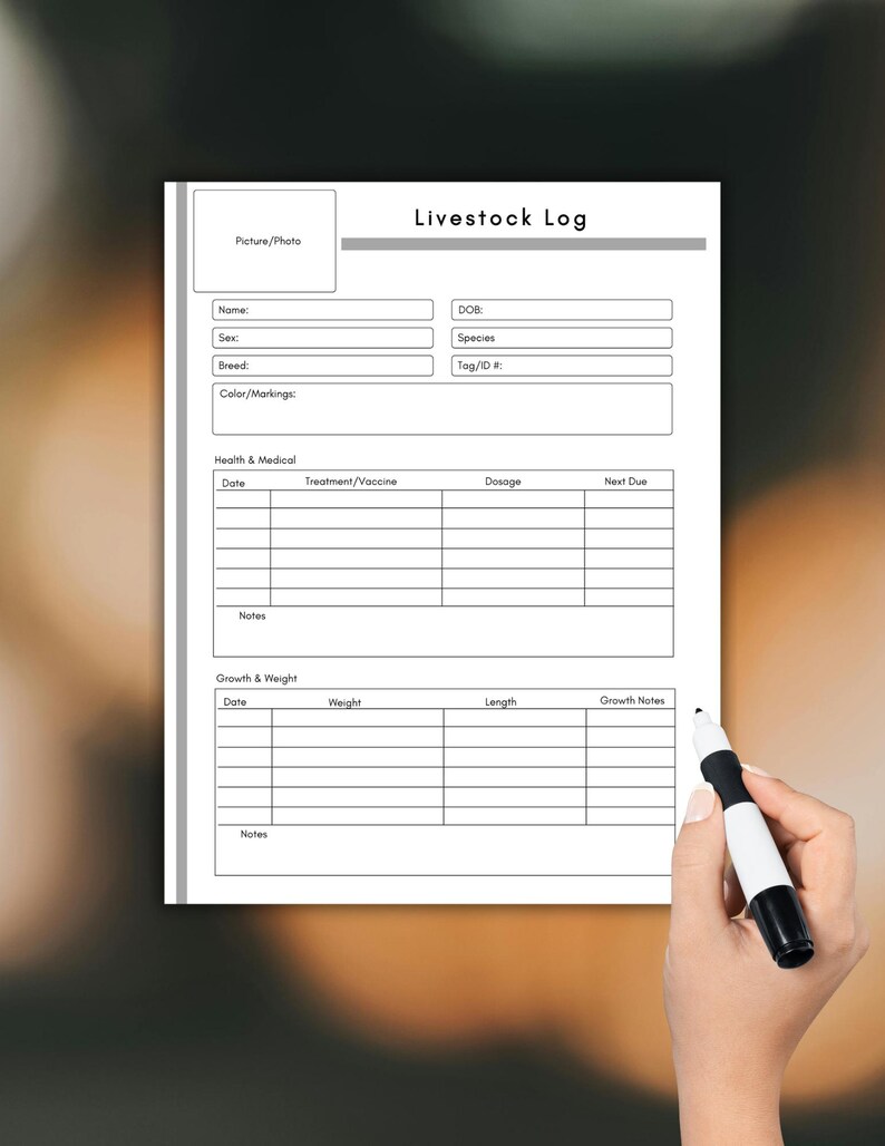 May include: A white livestock log form with sections for animal details, health records, and growth tracking. The form includes fields for name, breed, and colour, as well as space for notes. A hand holds a black and white marker.