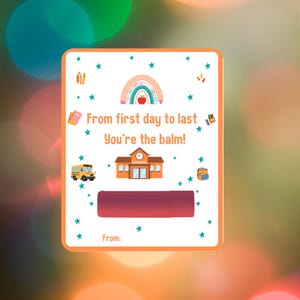 May include: A rectangular card with a school theme, featuring a rainbow, apple, school bus, and schoolhouse illustrations. Text reads "From first day to last, You're the balm!" and "From:" with a space for a name. A red lip balm is in the center.