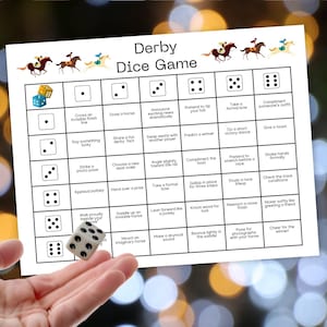 May include: A white game board titled "Derby Dice Game" with dice illustrations and instructions. A hand is holding a die with black dots. The game board features horse racing graphics and instructions for gameplay.