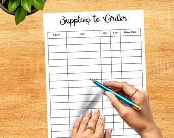 May include: A white paper titled "Supplies to Order" with a grid for item details. A teal pen is held by a person's hand, poised above the paper. A potted plant sits in the upper left corner on a wooden surface.