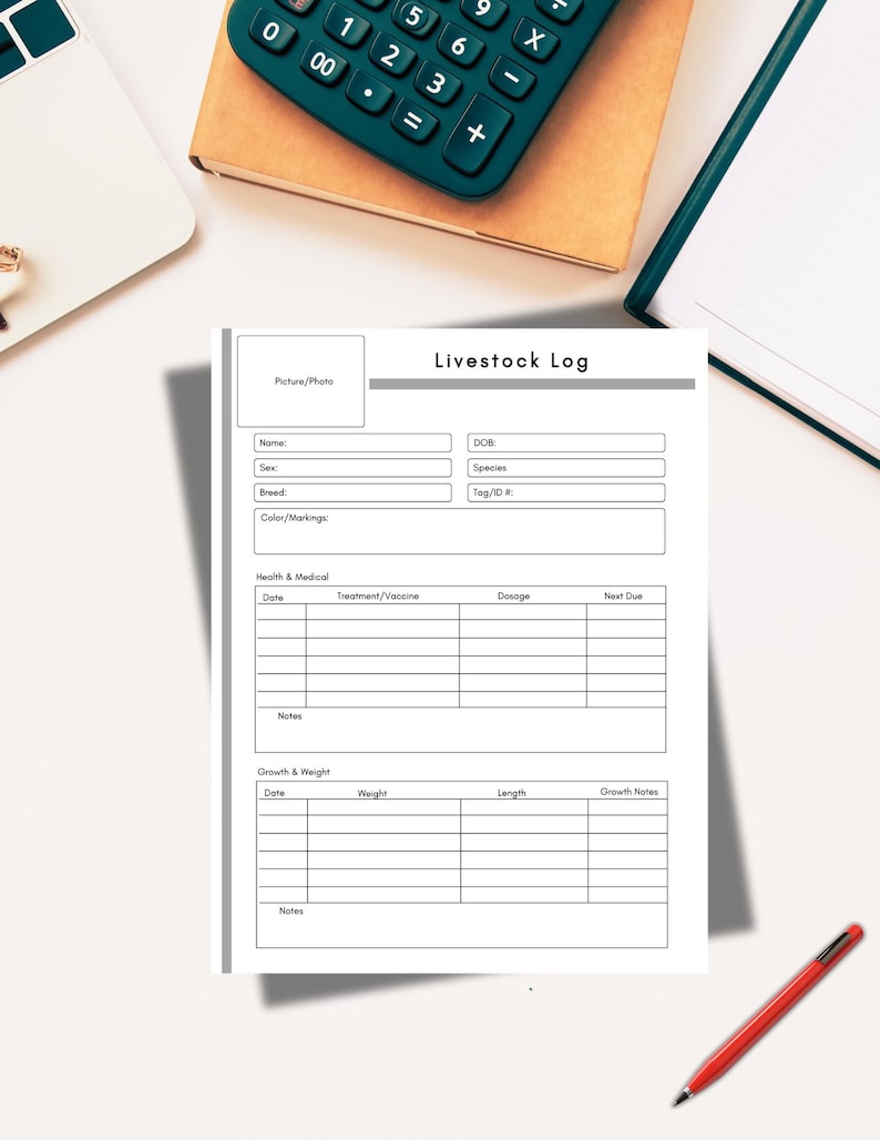 May include: A white "Livestock Log" form with sections for animal details, health records, and growth tracking. A green calculator, a notebook, and a red pen are on the white surface.