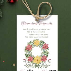 May include: A white gift tag with a floral wreath design. The tag has instructions for simmering potpourri, including adding 2 cups of water. The tag is addressed to Allie from Anna.