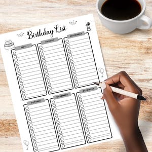 May include: A white paper titled "Birthday List" with sections for different months. The paper has a cake and balloon illustration. A cup of coffee sits to the right. A hand is holding a pen, ready to write on the list.