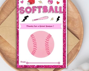 May include: A pink softball-themed greeting card with glitter accents, featuring a softball, helmet, and bat illustrations. The card reads "SOFTBALL" and "Thanks for a Great Season!" on a white background. The card is on a wooden tray with an envelope.