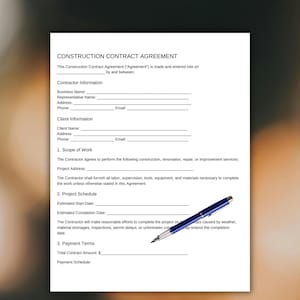 Può includere: Un documento bianco di contratto di costruzione con testo nero, comprese sezioni per le informazioni sull'appaltatore e sul cliente, l'ambito dei lavori, il programma del progetto e i termini di pagamento. Una penna blu è appoggiata sul documento.