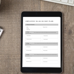 Könnte beinhalten: Ein digitales Tablet zeigt eine 30-60-90-Tage-Planvorlage für Mitarbeiter. Die Vorlage enthält Abschnitte für Mitarbeiterinformationen, Lernziele, Leistungsziele und persönliche Ziele für jeden 30-Tage-Zeitraum.