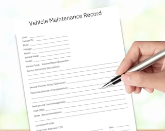 May include: A white Vehicle Maintenance Record form with black text, being filled out with a silver pen. The form includes fields for vehicle information, service details, and signatures. The form is on a wooden surface.