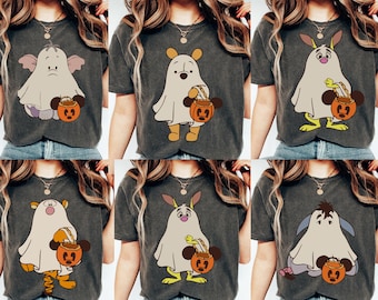May include: Six different t-shirts featuring various Disney characters dressed as ghosts holding a jack-o-lantern. The shirts are all a dark gray color.