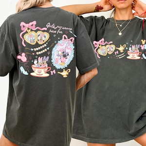 May include: Dark grey t-shirt with a colourful graphic of Disney characters, including Minnie and Daisy Mouse, teacups, and bows. The text "Girls just wanna have fun" is also visible. The shirt has a relaxed fit.