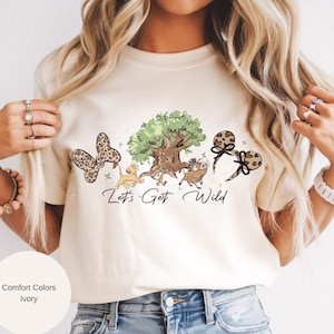 May include: A white ceramic mug with a black handle and the text "But First, Coffee" in a bold, black font. The mug is set against a blurred background, suggesting a cozy setting.