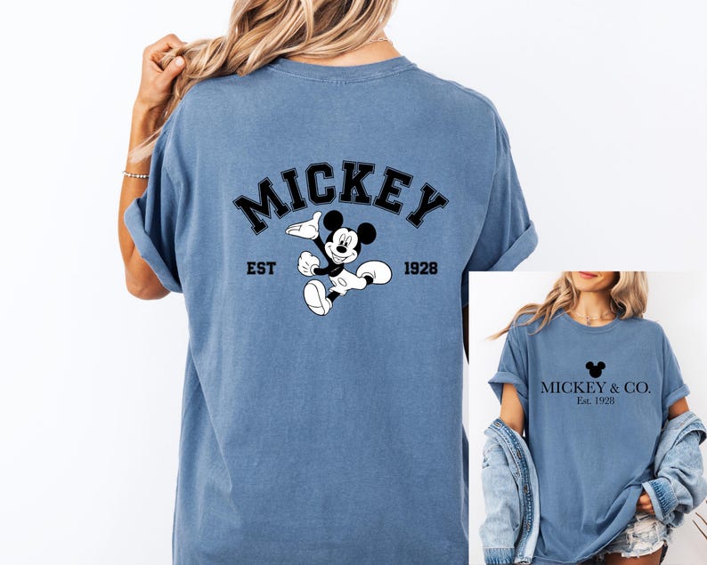 Puede incluir: Dos camisetas azules con un dise&ntilde;o de Mickey Mouse. La parte posterior de una camiseta dice "Mickey Est. 1928" con un dibujo animado de Mickey Mouse. La parte delantera de la otra camiseta dice "Mickey & Co. Est. 1928" con una cabeza de Mickey Mouse.