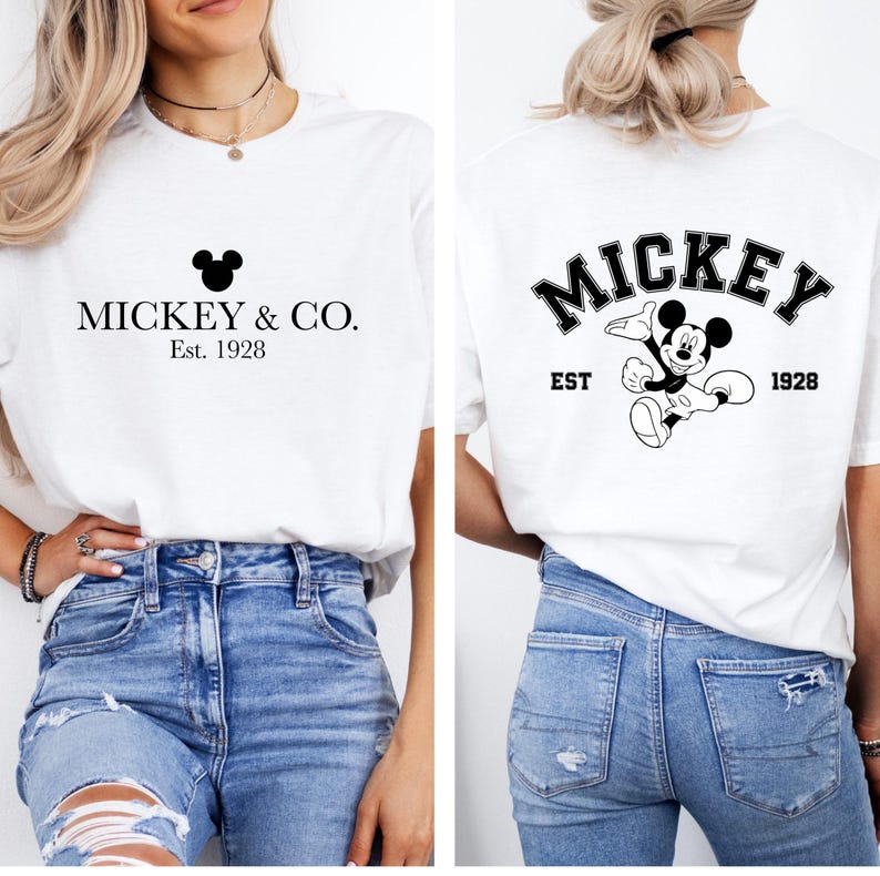 Puede incluir: Camiseta blanca con una cabeza de Mickey Mouse negra y el texto "Mickey & Co. Est. 1928" en la parte delantera. La parte posterior de la camiseta tiene un gr&aacute;fico negro de Mickey Mouse con el texto "Mickey Est. 1928" en un arco negro.