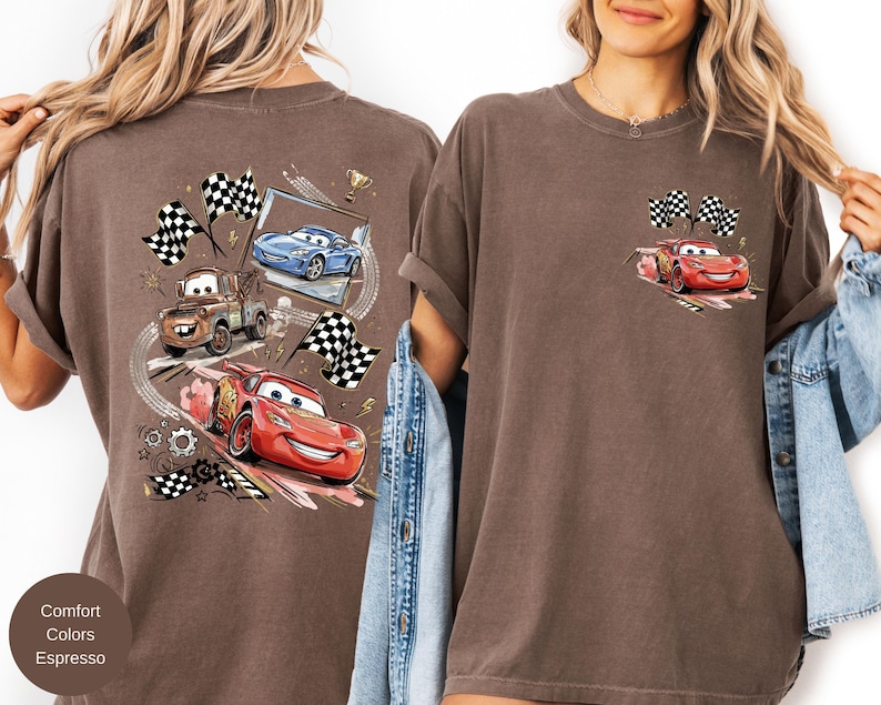 Puede incluir: Camiseta color espresso con un gr&aacute;fico de coches de carreras animados, incluido un coche rojo con una cara sonriente y banderas a cuadros. La parte posterior de la camiseta tiene un dise&ntilde;o m&aacute;s grande con m&uacute;ltiples coches y elementos de carreras.