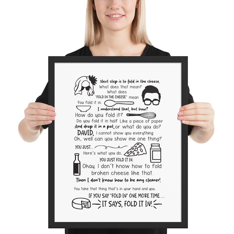 May include: A framed black and white print with text and illustrations. The text reads "Next step is to fold in the cheese." The print includes illustrations of a bowl, spoon, glasses, cheese, and a bottle.